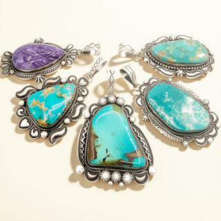 Four turquoise pendants and one purple pendant on a beige background