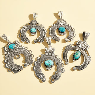 Five silver and turquoise pendants on a beige background