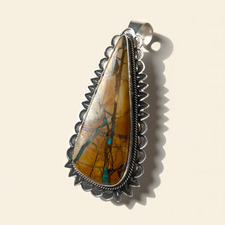 Pendant with a large stone and silver border on a beige background