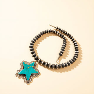 Pearl necklace with turquoise star stone on a beige background