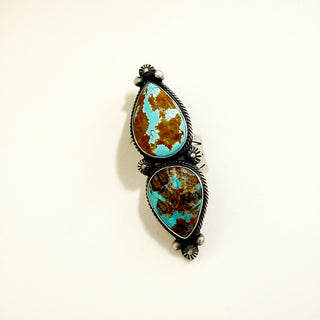 Turquoise and brown ring on a beige background