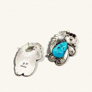 Silver earrings with turquoise stone on a white background