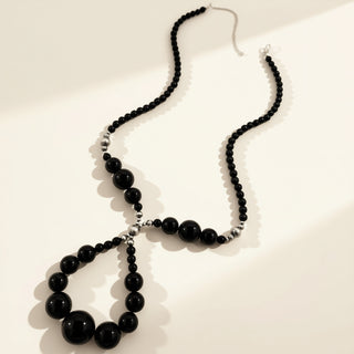 Black beaded necklace on a white background