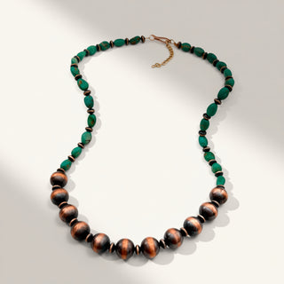Necklace with green and brown beads on a light gray background