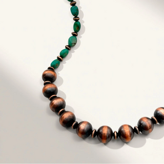 green and brown beaded necklace on a beige background