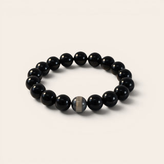 Black beaded bracelet on a light beige background