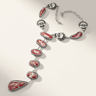 Necklace with red stone pendants and silver accents on a light background