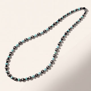 Necklace with black and turquoise beads on a light background