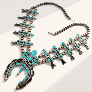 silver necklace with turquoise stones on a beige background