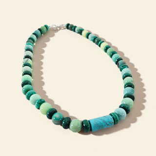 Necklace with green and blue beaded design on a beige background