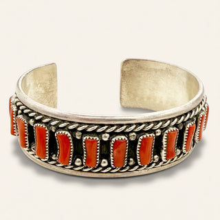 Silver bracelet with red stones on a white background