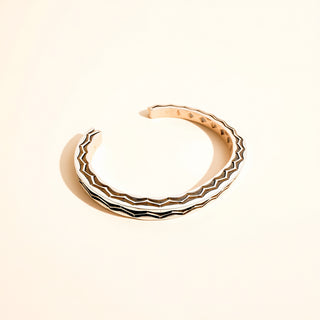 Silver and black cuff on a beige background