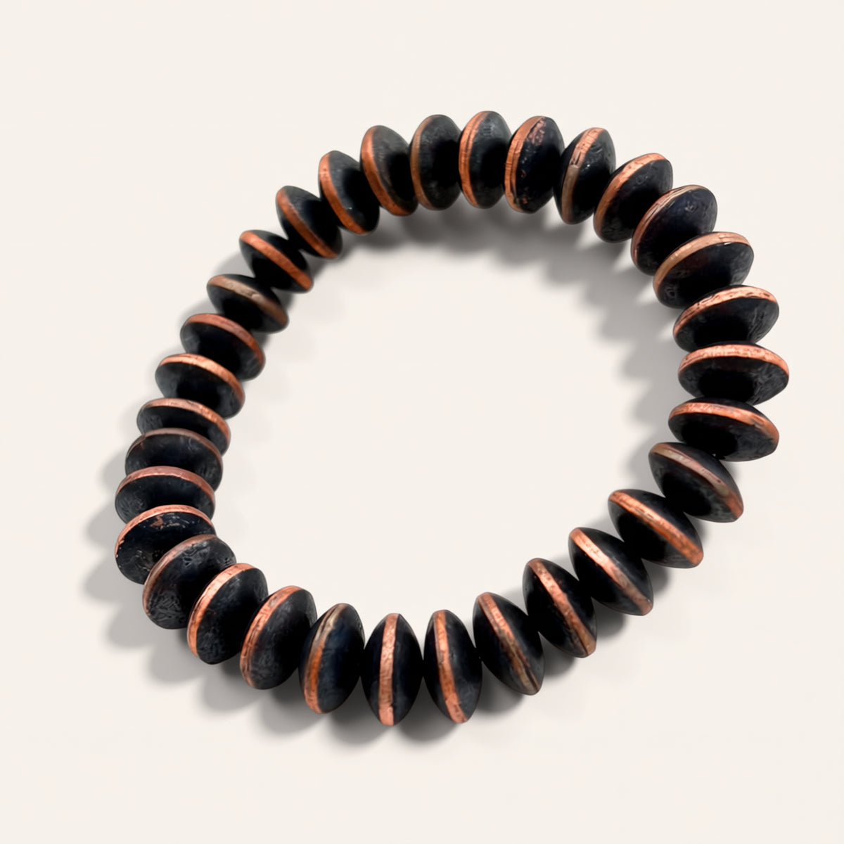 Black and copper beaded bracelet on a light gray background