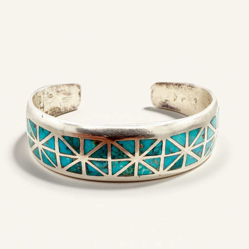 silver cuff with turquoise stones on a beige background