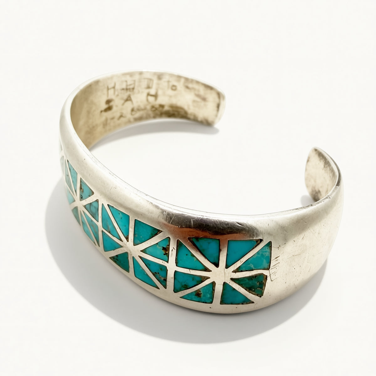 Cuff with turquoise stones on a beige background