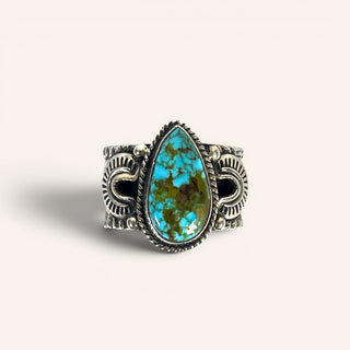 Turquoise stone ring with silver band on a light gray background