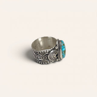 Silver ring with turquoise stone on a light beige background