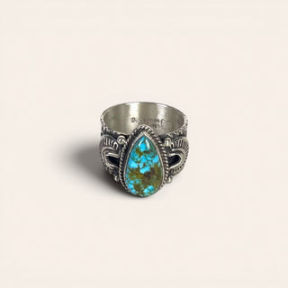 Silver ring with a turquoise stone on a beige background
