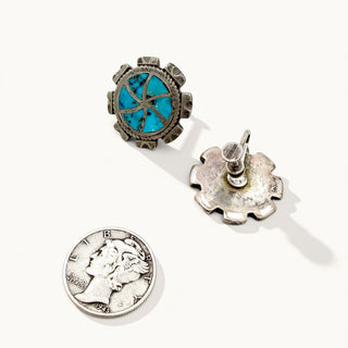 Silver earrings with turquoise stones and a coin on a white background