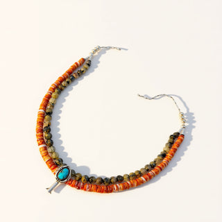 Necklace with orange and green beads on a white background