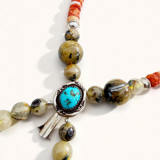 Beaded bracelet with turquoise stone and silver clasp on a white background