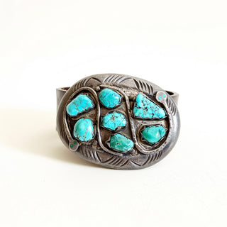 Silver belt buckle with turquoise stones on a white background