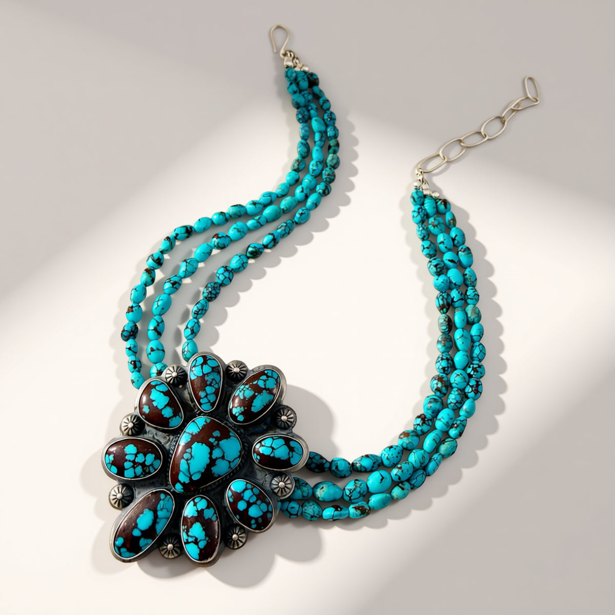 turquoise beaded necklace with turquoise flower pendant on a beige background