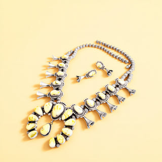 Jewelry set with necklace and earrings on a yellow background