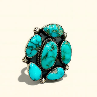 Turquoise stone ring with silver band on a beige background