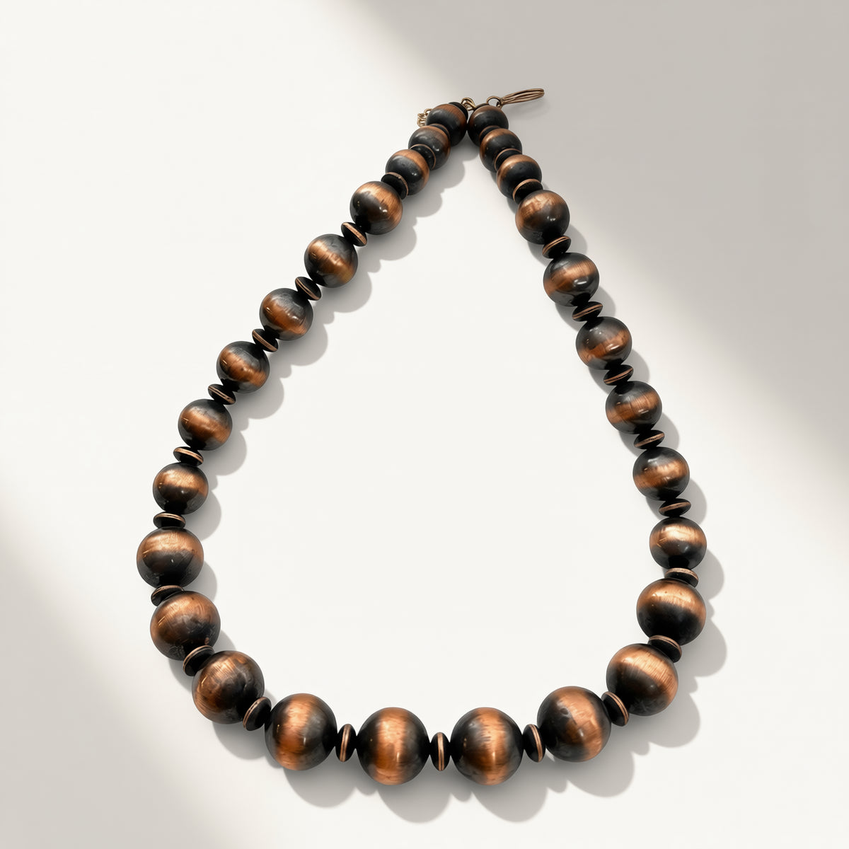 copper beaded necklace on a light gray background