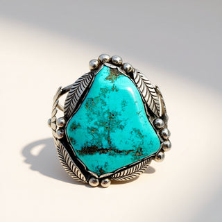Turquoise ring with silver detailing on a light background