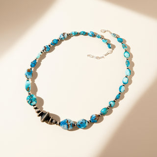 Blue beaded necklace on a beige background
