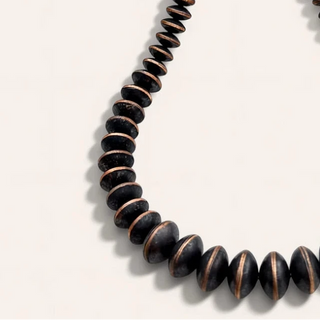 black and brown necklace on a beige background