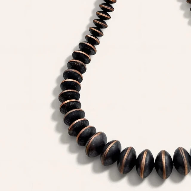 black and brown necklace on a beige background