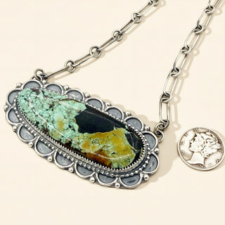 Necklace with a pendant featuring a natural stone and a coin charm on a beige background