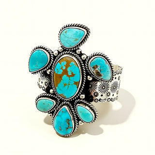 Turquoise stone cuff with silver detailing on a white background