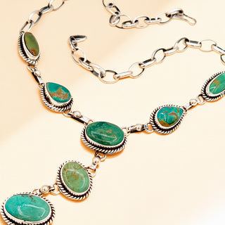 Necklace with green gemstones on a beige background