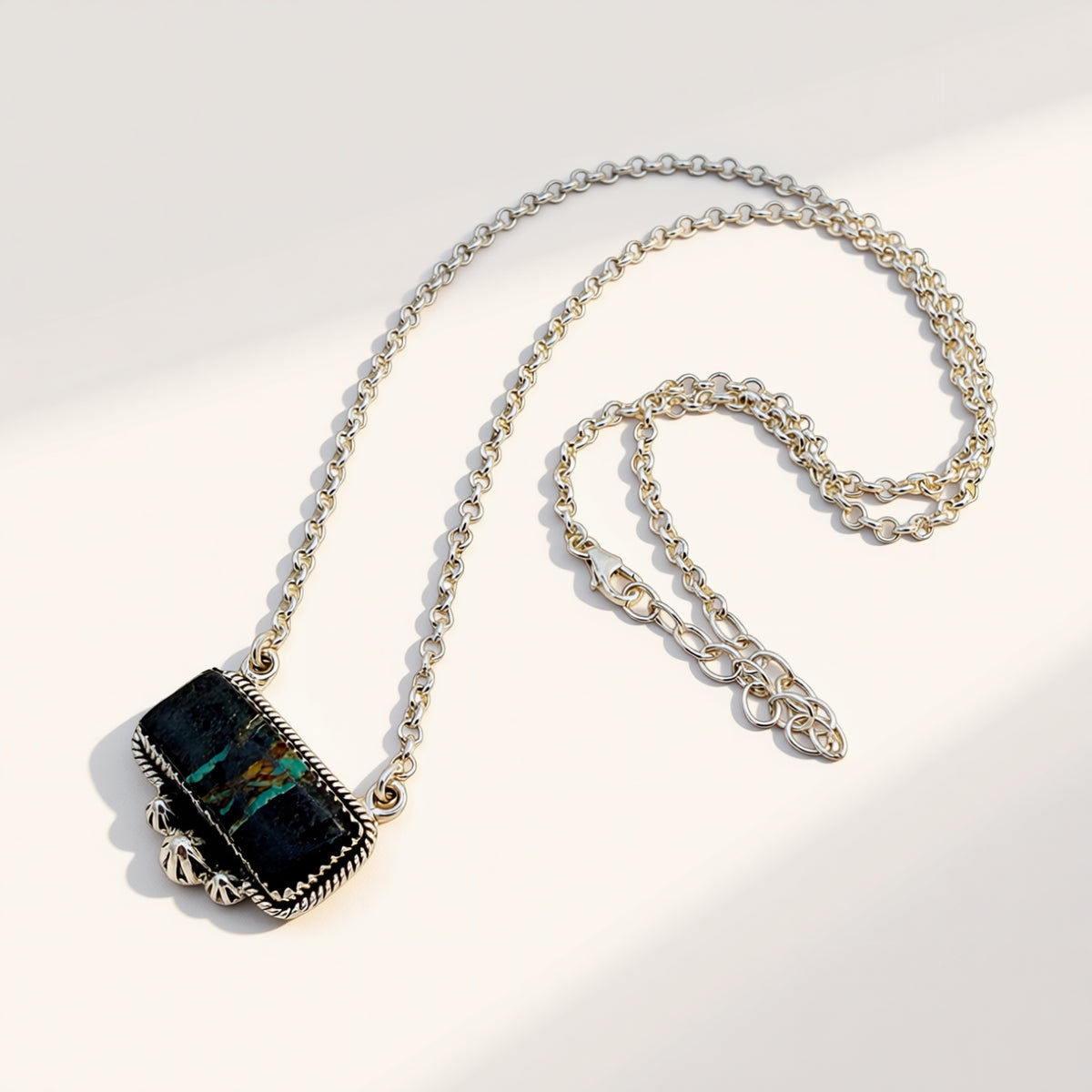 Necklace with a black pendant on a light gray background