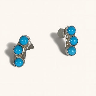 Pair of turquoise stud earrings on a white background