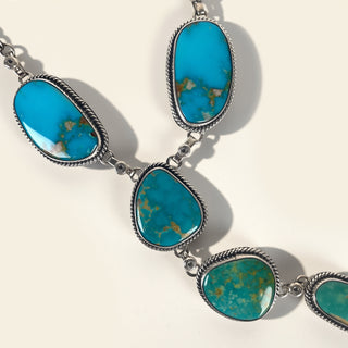 Turquoise stone necklace with silver setting on a light background