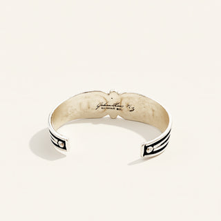 Silver bracelet with black accents on a white background