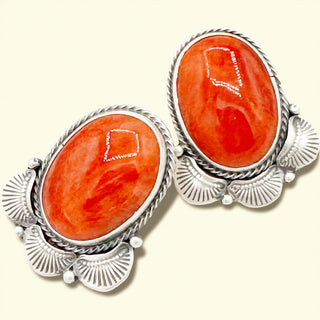 Pair of earrings with red stone and silver setting on a white background