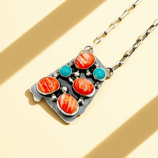 Necklace with colorful stone pendant on a beige background