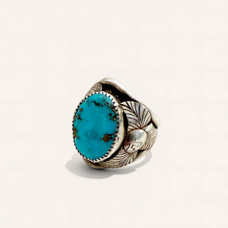 Silver ring with turquoise stone on a beige background