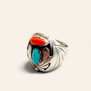 silver ring with red and turquoise stone on a beige background