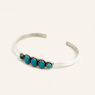 Silver bracelet with turquoise stones on a white background