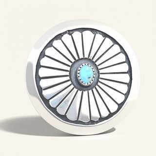 Close-up of a silver jewelry with a blue center on a white background