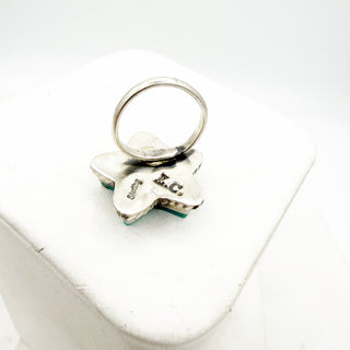 Silver keychain with engraved text on a white surface