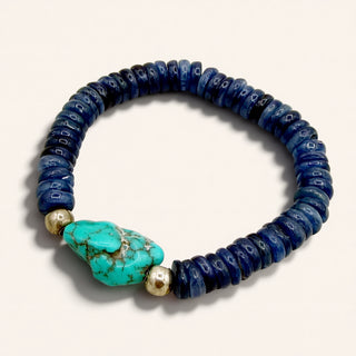 Bracelet with blue beads and a turquoise stone on a white background