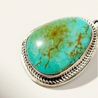 Turquoise stone earrings with silver settings on a light background